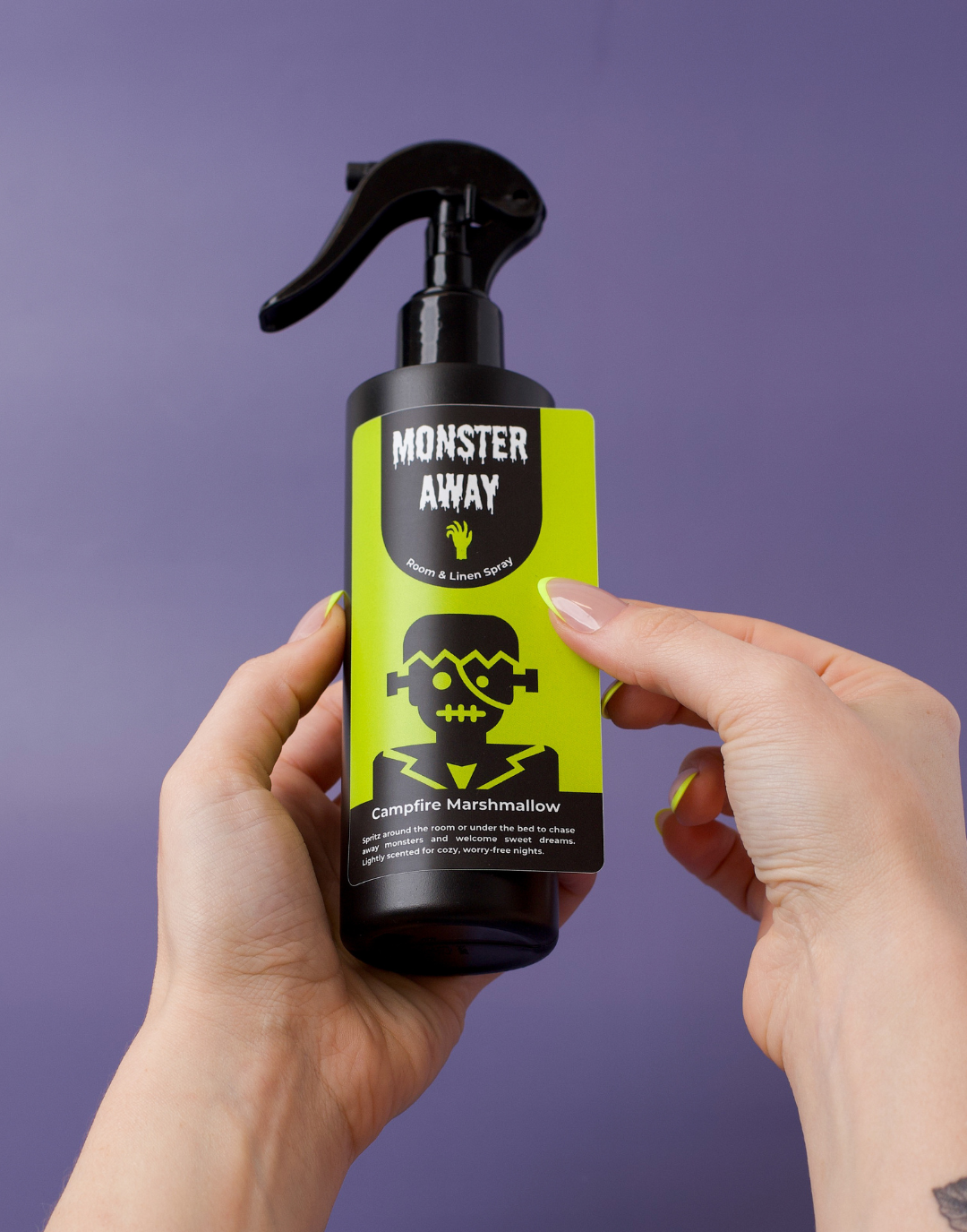 Hands placing a monster away label on the spray bottle.